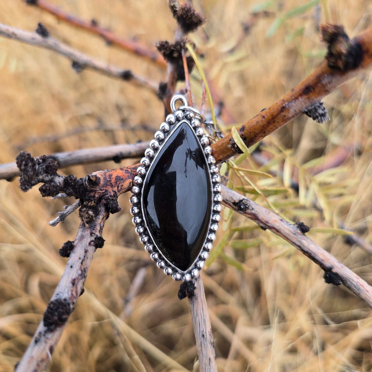 Sterling and black obsidian pendant displayed on natural background front view