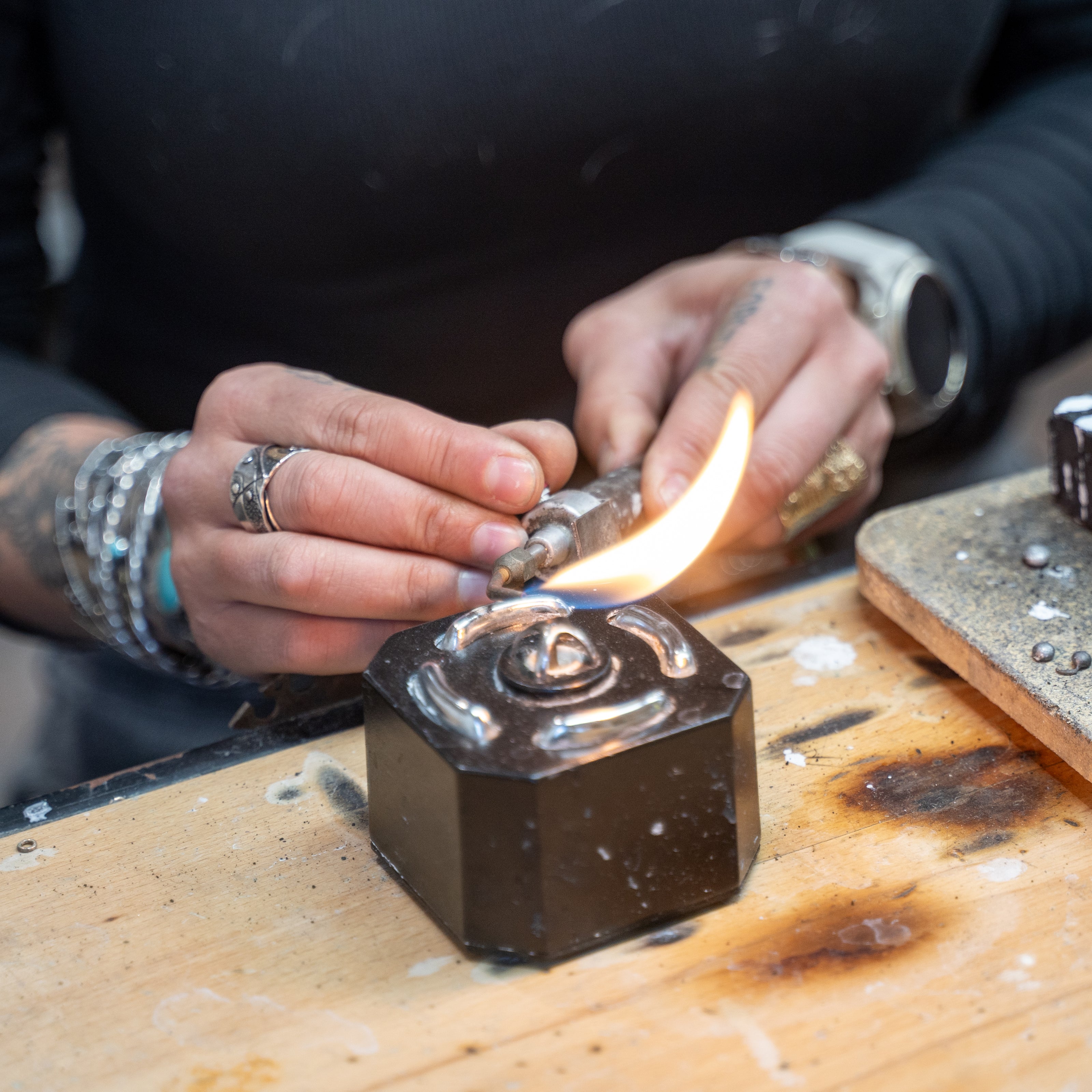 Torch work in a traditional silversmith studio building hand-forged jewelry