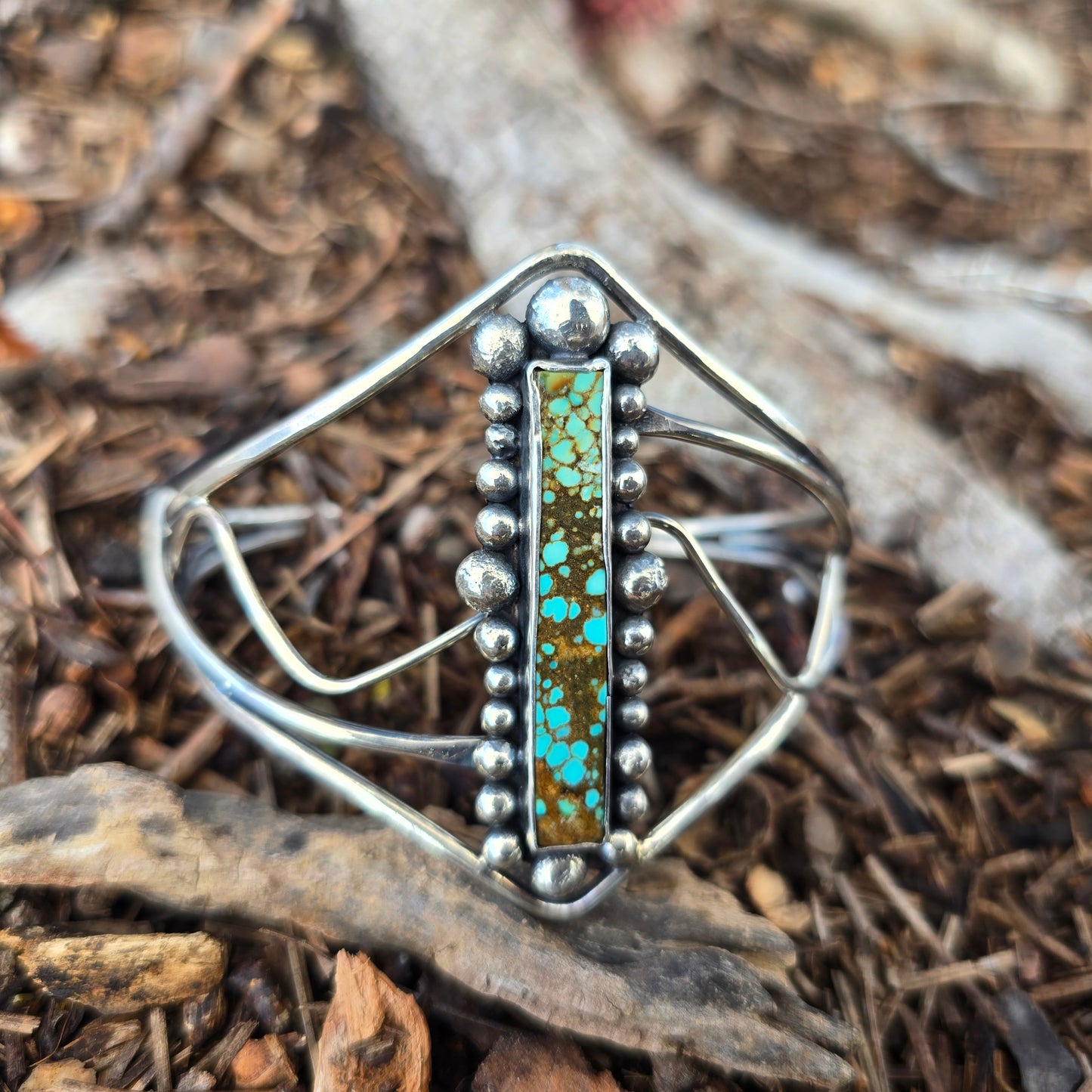 Front view of rectangular turquoise set in hand-forged sterling silver cuff