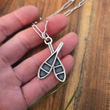 Load image into Gallery viewer, sterling double snowshoe pendant displayed on hand
