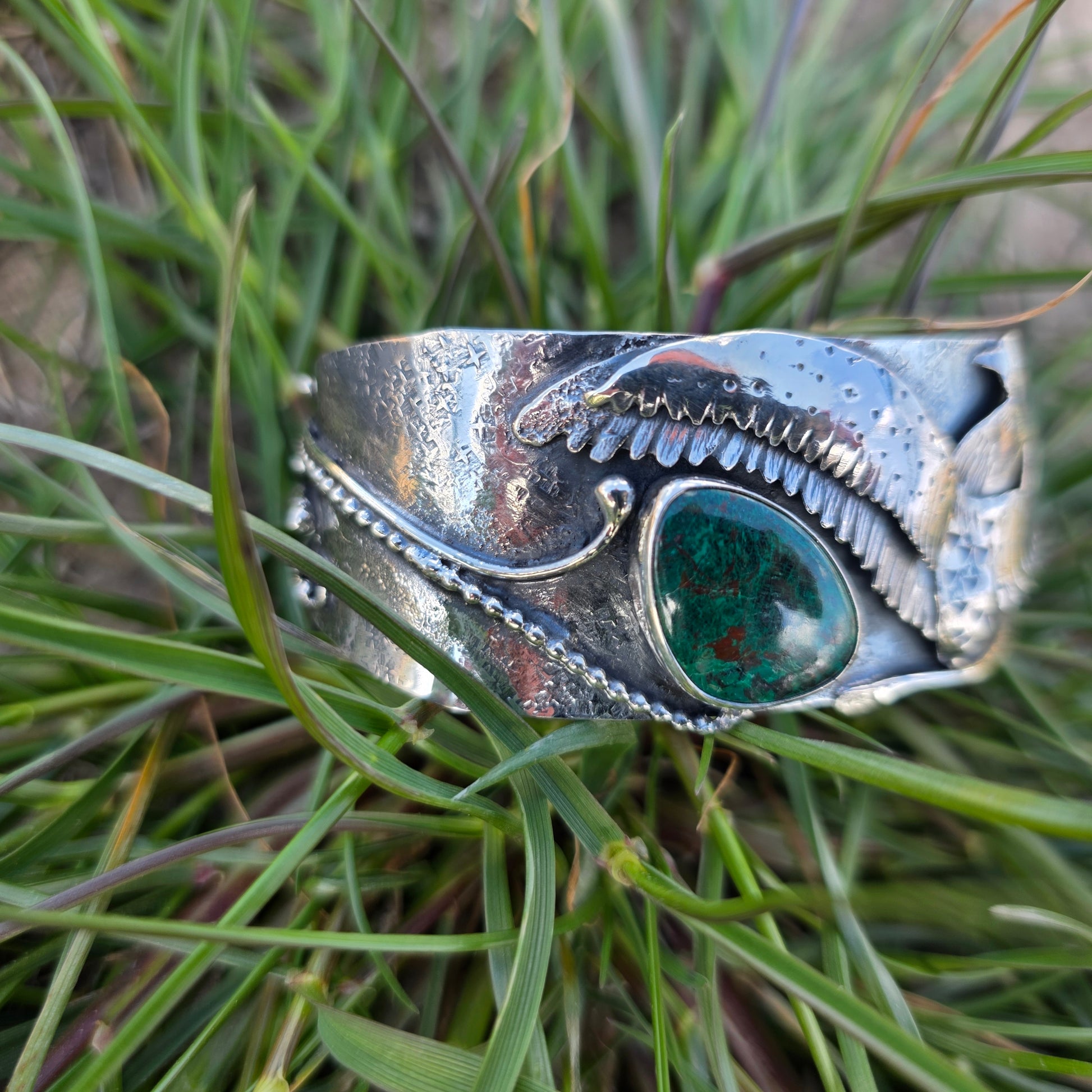 Sterling silver loon taking flight 3d cuff bracelet displayed in grass