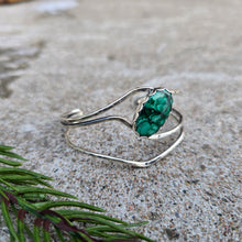 Load image into Gallery viewer, Front angled view of a sterling silver cuff bracelet set with an oval malachite stone and finished with a polished surface.
