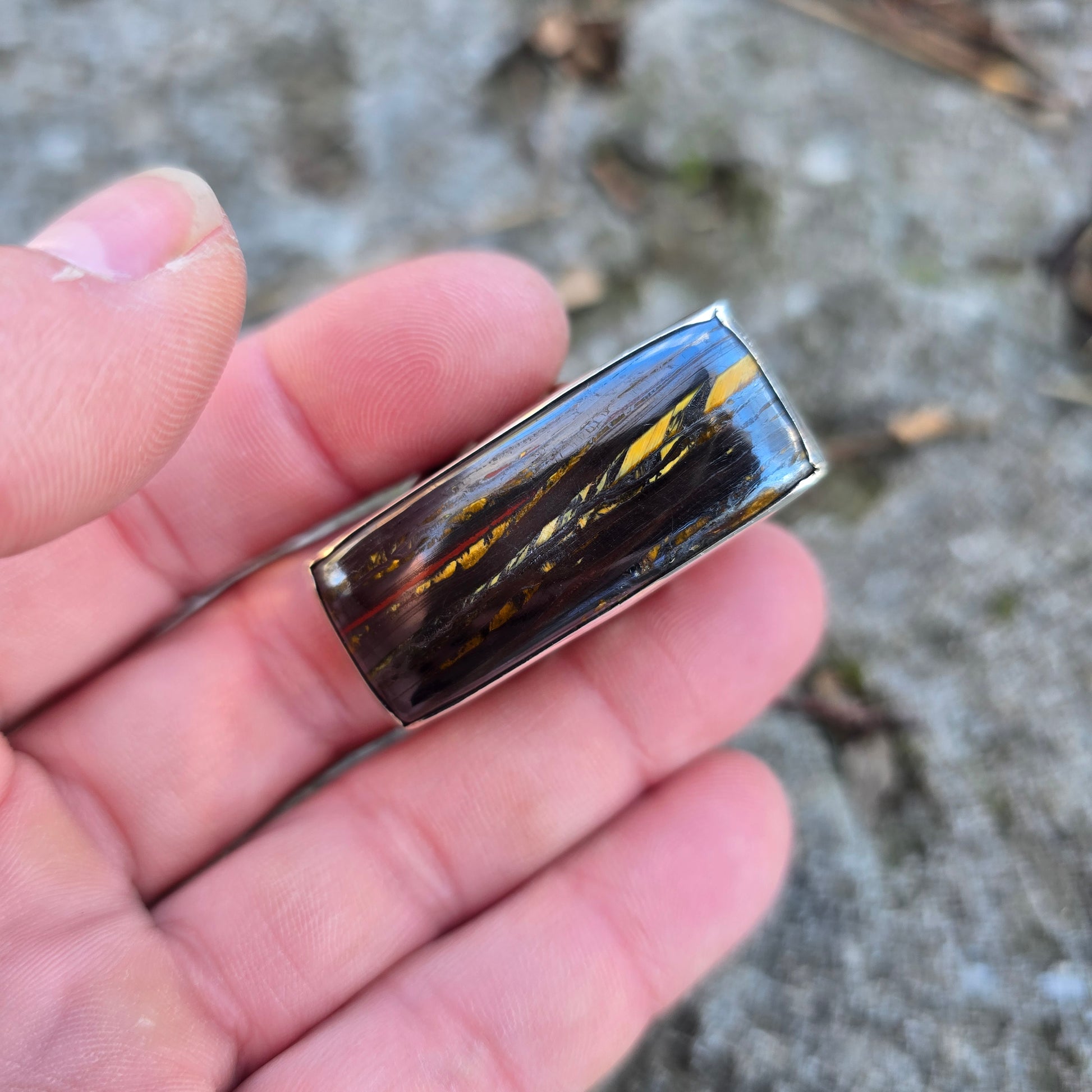 silver ring with brown stone displayed on hand