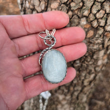 Load image into Gallery viewer, silver and white moonstone pendant displayed on hand 
