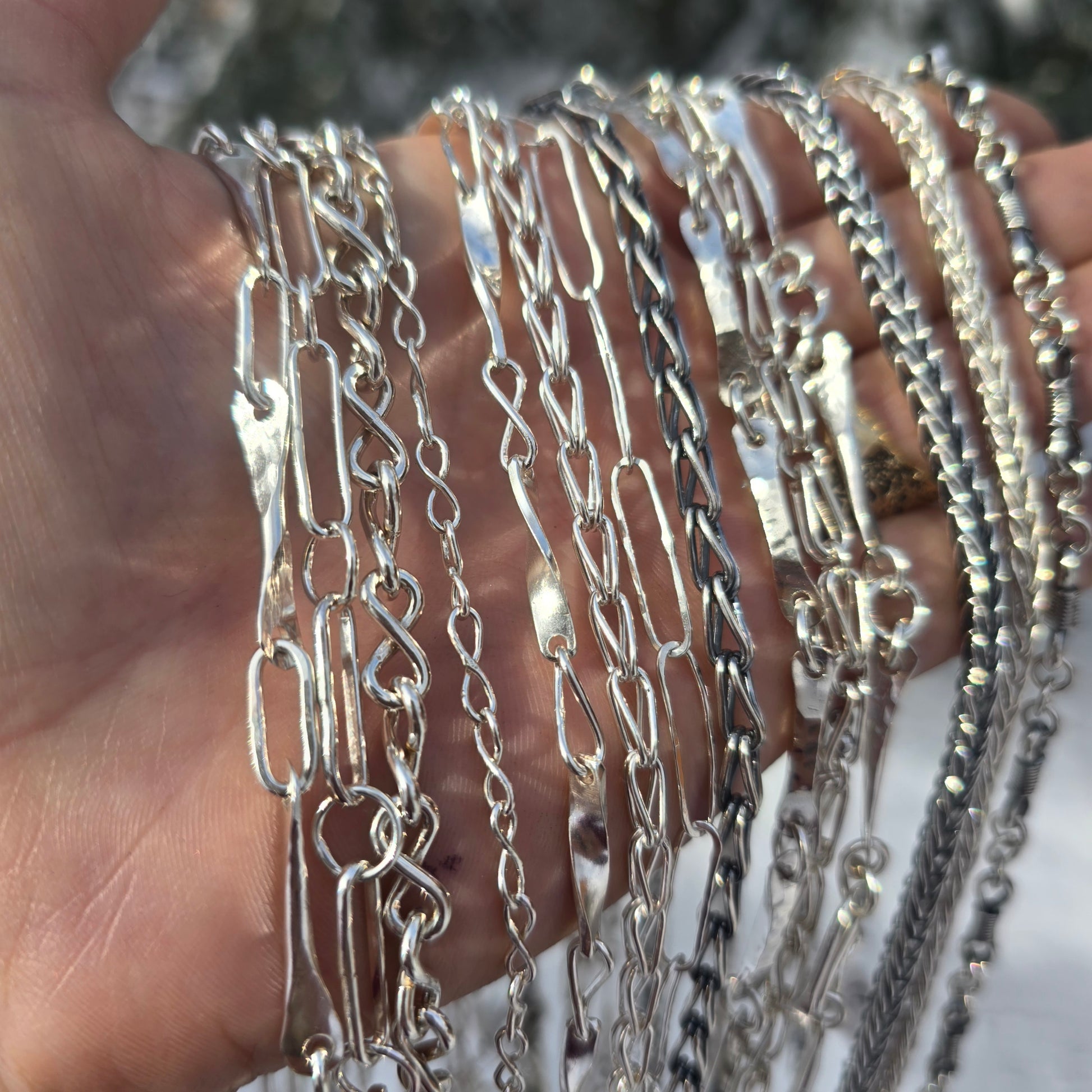 sterling silver shiny and oxidized chains shown on hand angled