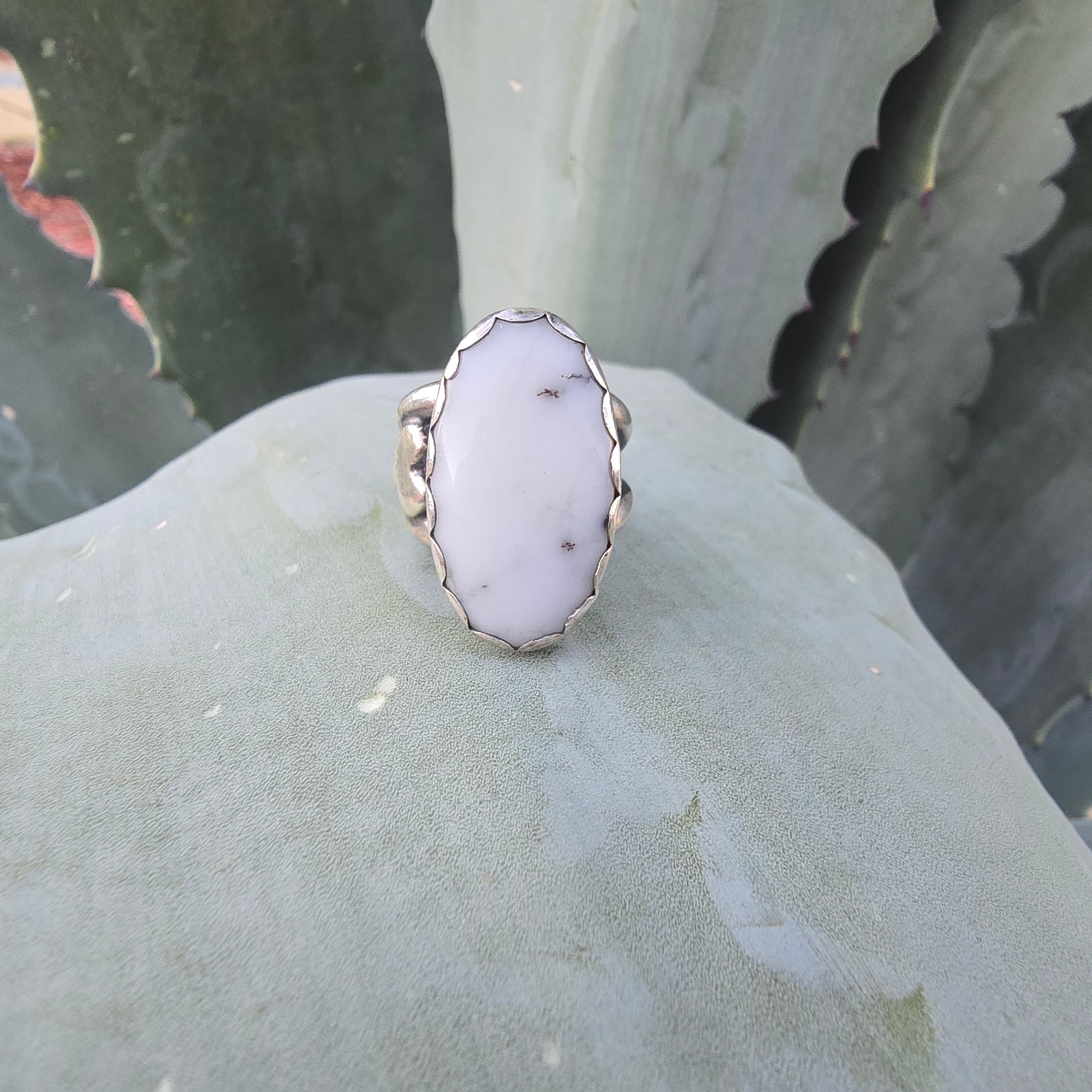 Sterling silver and white ring front view displayed in natural setting.