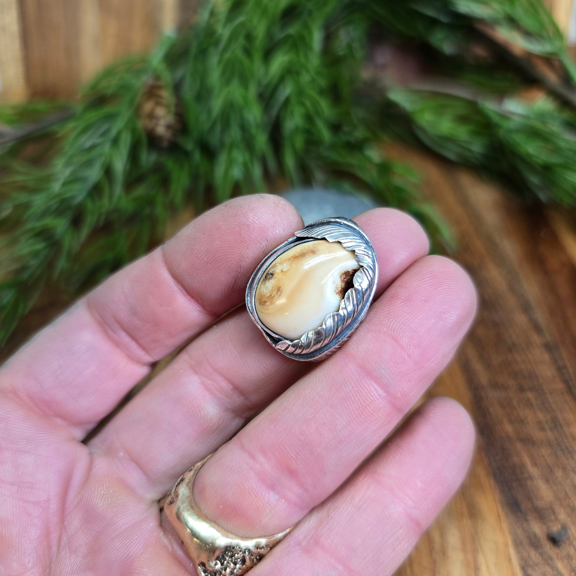 sterling silver elk ivory feather-wrapped ring worn on hand