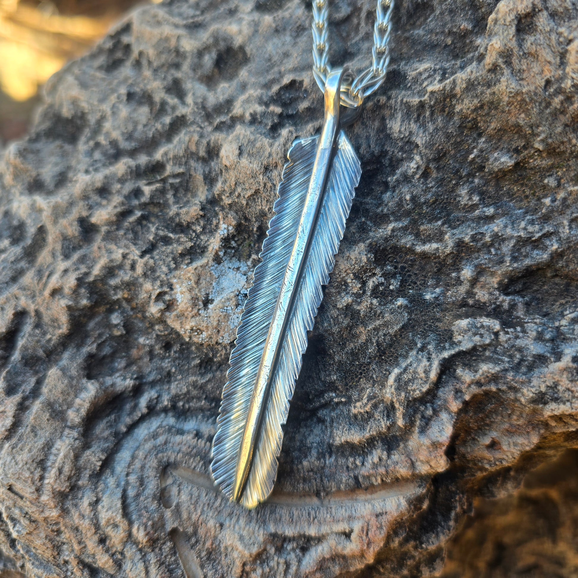 Heavy sterling silver feather pendant, hand stamped and formed, with an oxidized finish and defined surface detail.