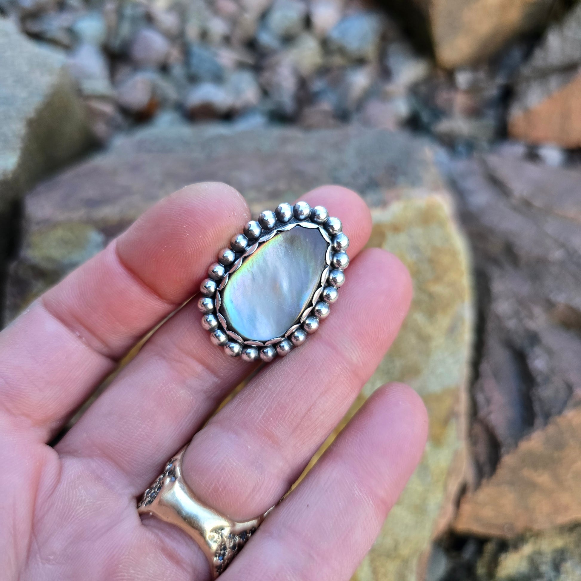 Beaded bezel sterling silver ring showcasing an oval White Mother of Pearl centerpiece