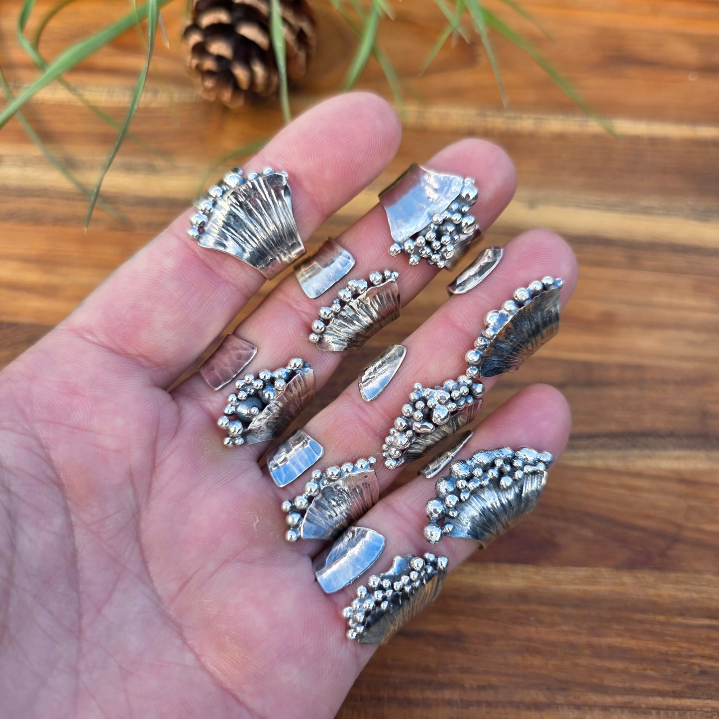 Sterling silver pearl ridge adjustable ring collection displayed across hand