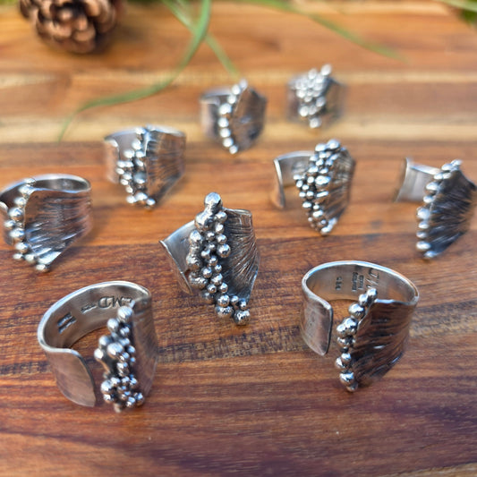 sterling silver collection of pearl ridge adjustable rings on natural background