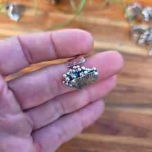 Load image into Gallery viewer, Hand wearing a silver ring with leaf design on a wooden surface
