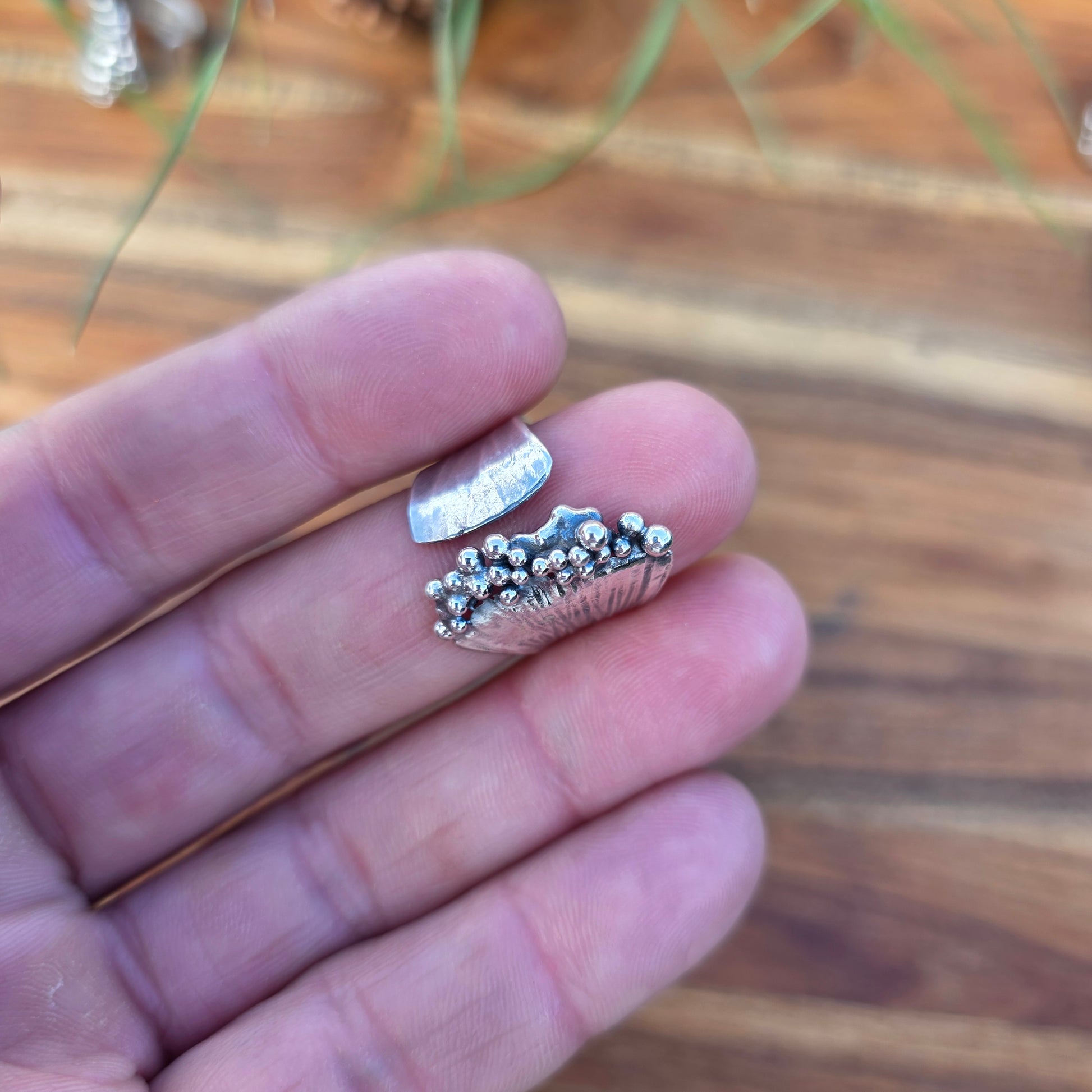 Sterling silver pearl ridge adjustable ring displayed on finger with cluster top view