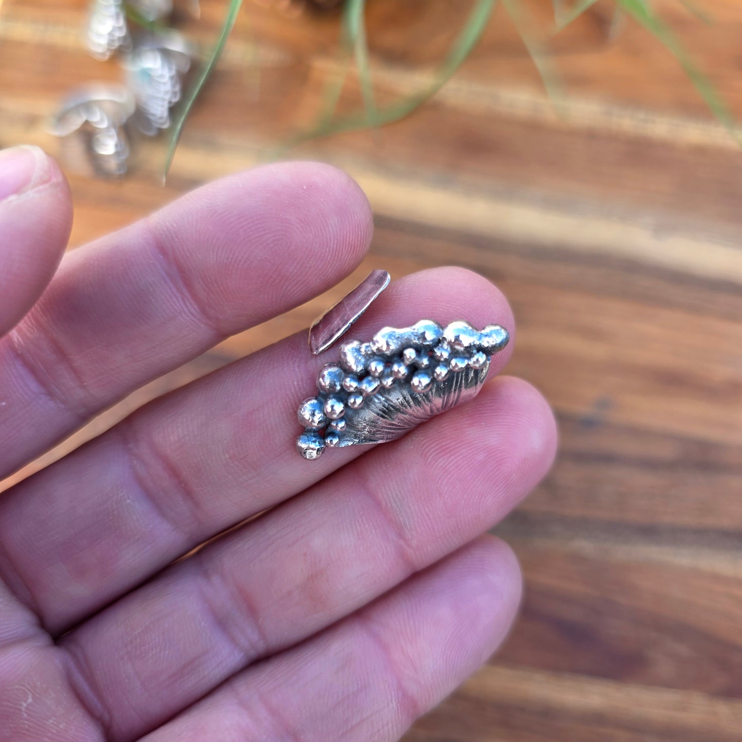 Sterling silver pearl ridge adjustable ring displayed on finger top view