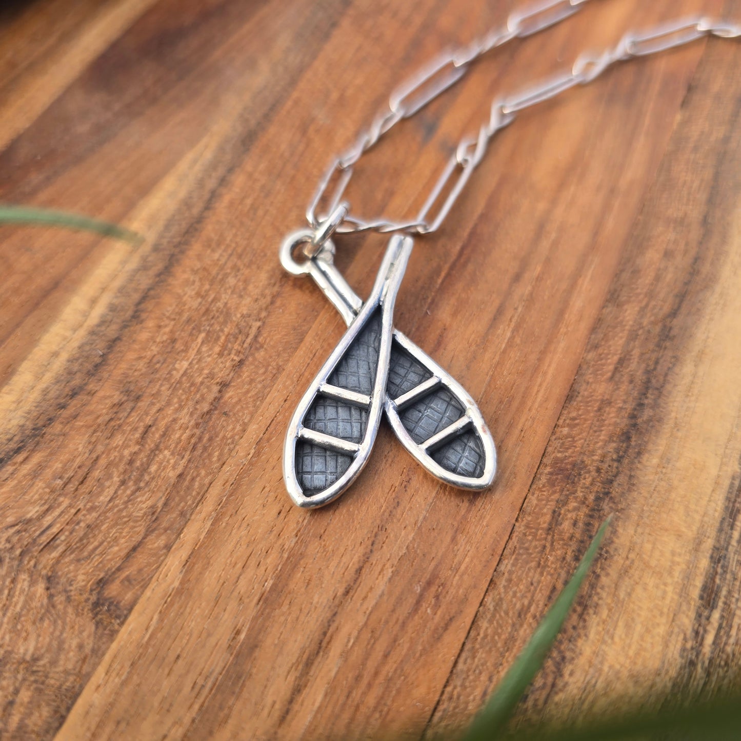 silver double snowshoe pendant displayed on chain angled view
