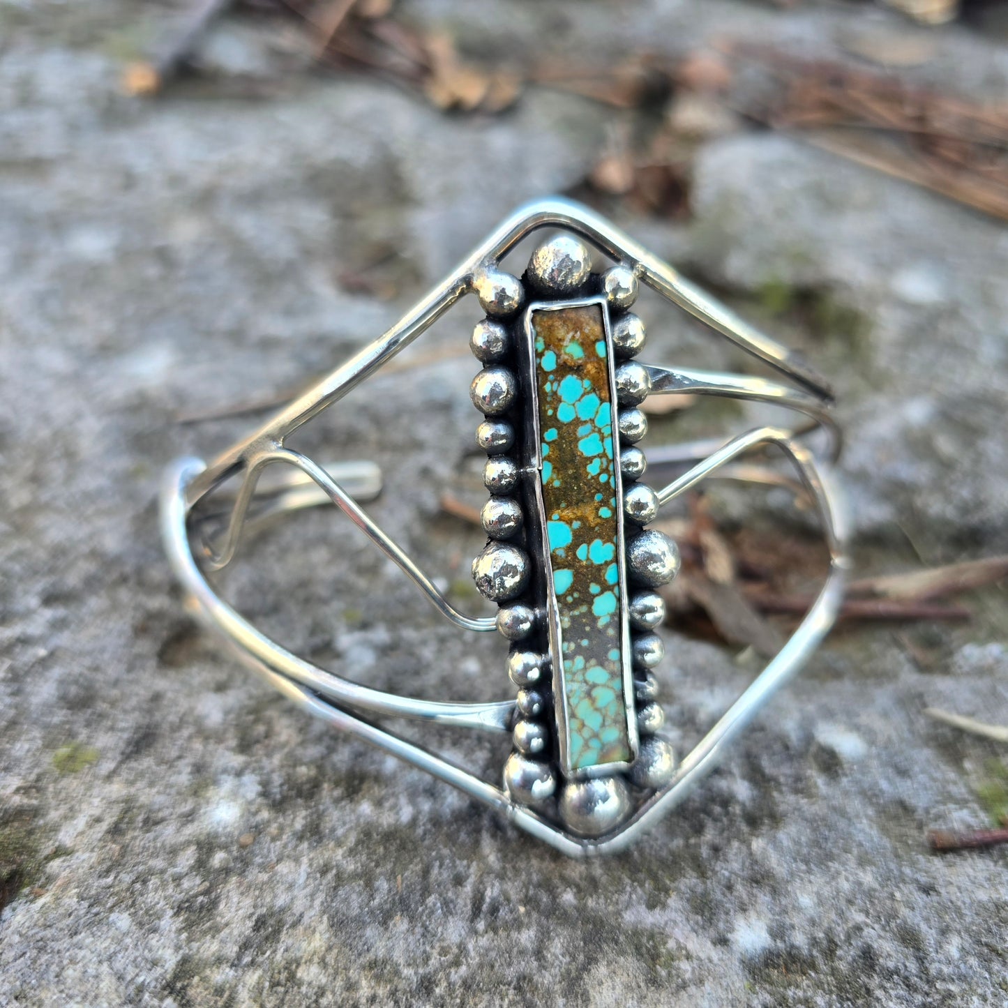Rectangular turquoise set in hand-forged sterling silver cuff angled view