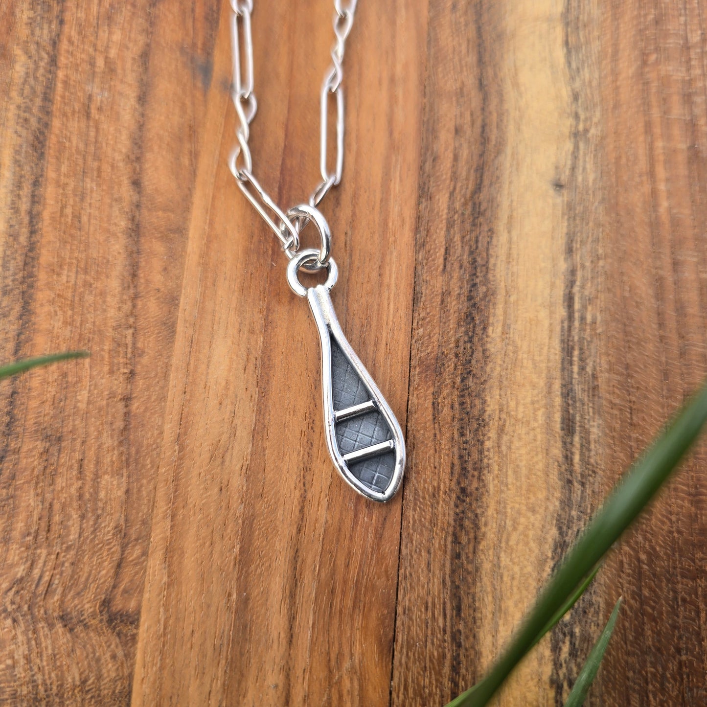 sterling silver snowshoe pendant displayed on chain top view