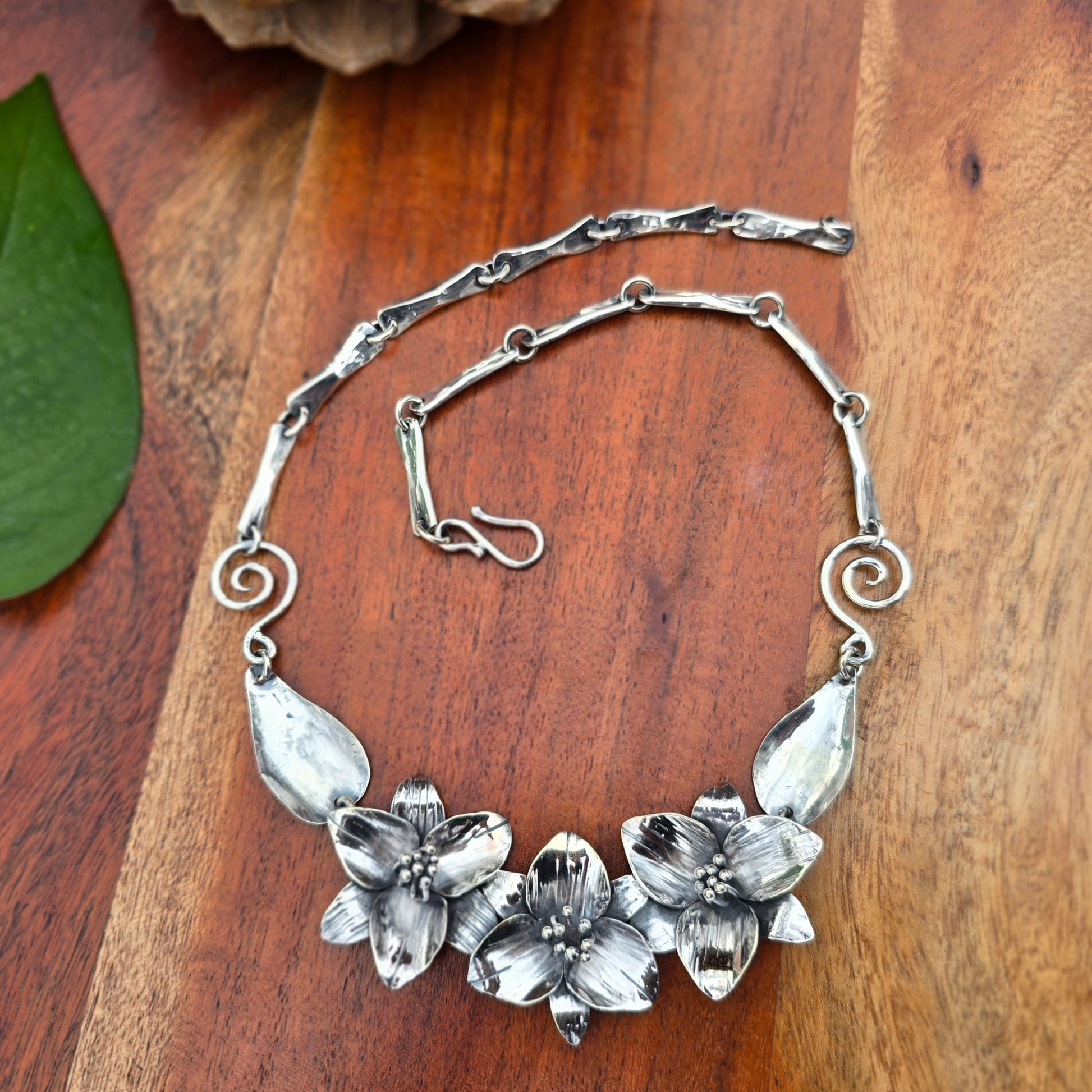 sterling silver necklace with three trillium flowers, leaf links, and heavy chain back