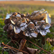 Load image into Gallery viewer, silver trillium necklace displayed on pinecones
