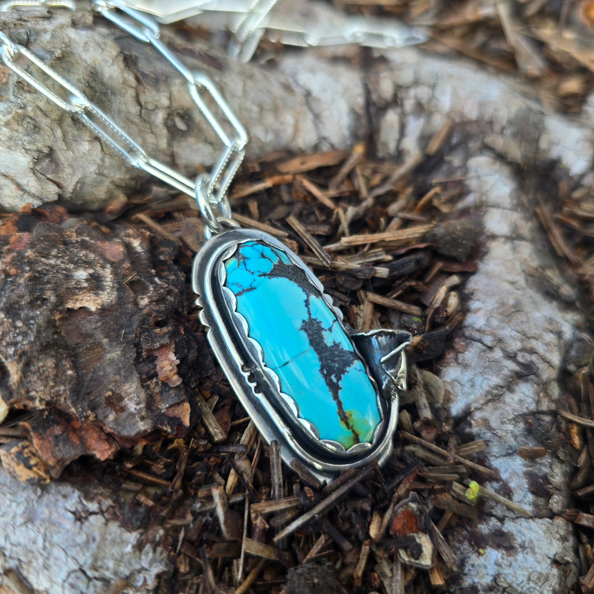 angled view of turquoise and calla lily pendant