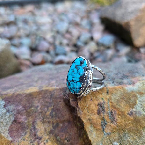 front view of turquoise ring with feather wrap and double shank band