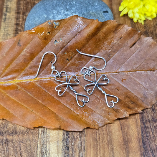 Oxidized sterling silver earrings featuring the Twisted Heart Cross design, handmade by Adirondack silversmith Emily Dicob.